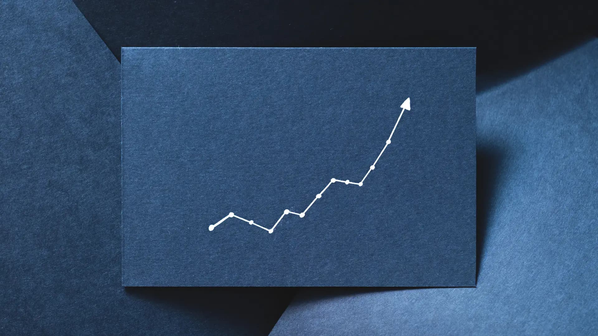 White zigzag upward arrow on a dark blue background symbolizing progress despite obstacles