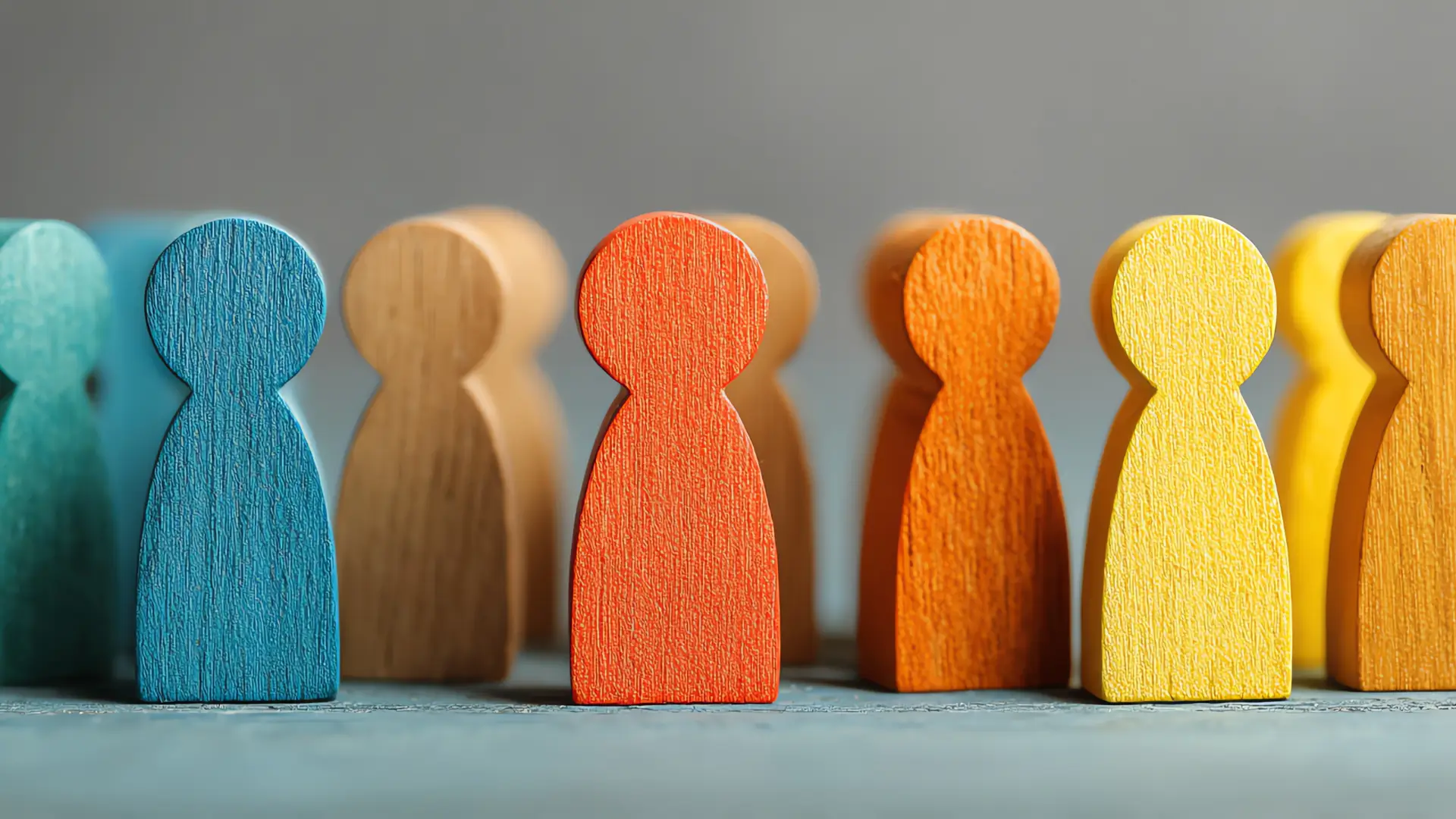 Several wooden figurines in different colors representing different people, evoking the diversity of buyer profiles and of the ways to sell online
